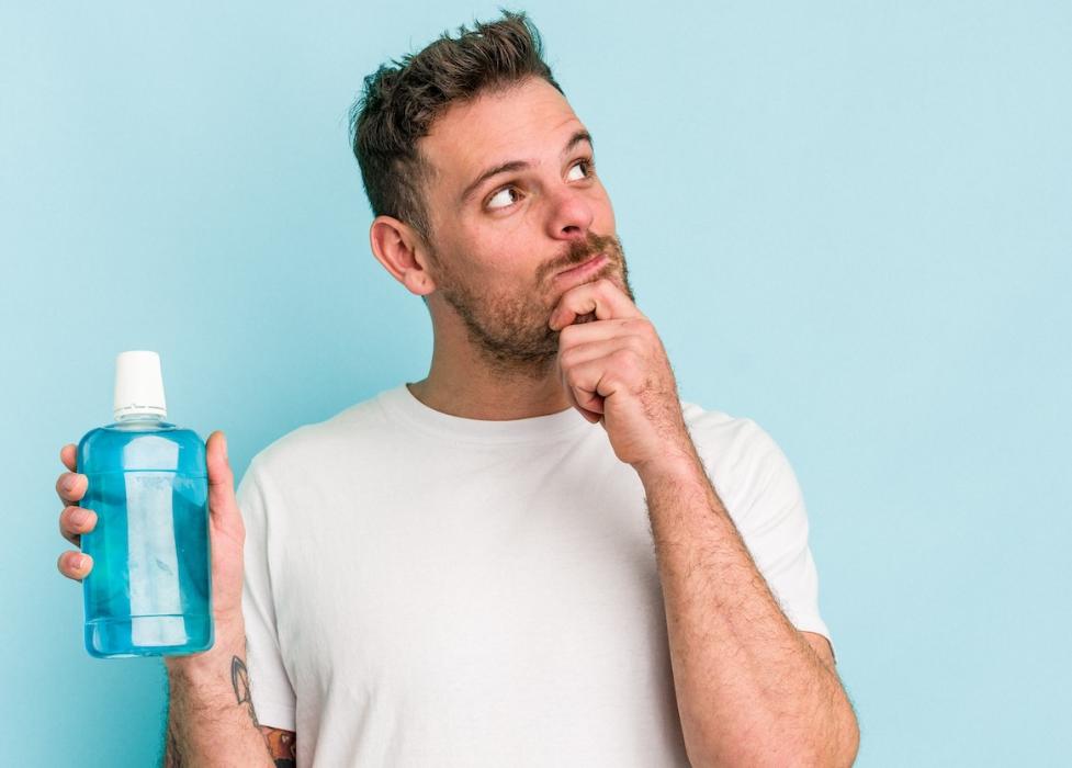 Man holding mouthwash and thinking, scottsdale az