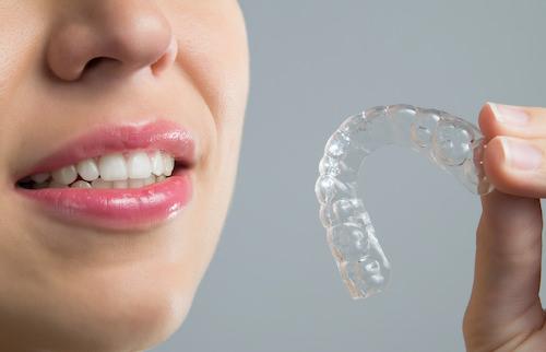Woman holding an invisalign aligner, scottsdale az