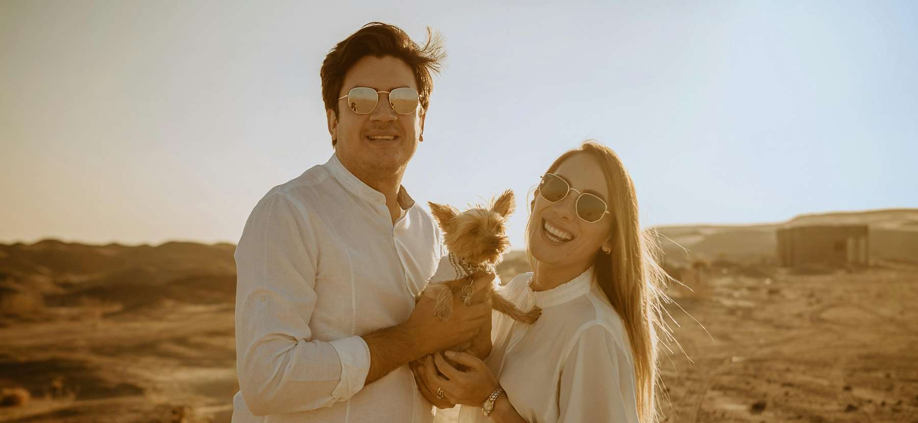 Couple smiling holding dog outside, scottsdale az