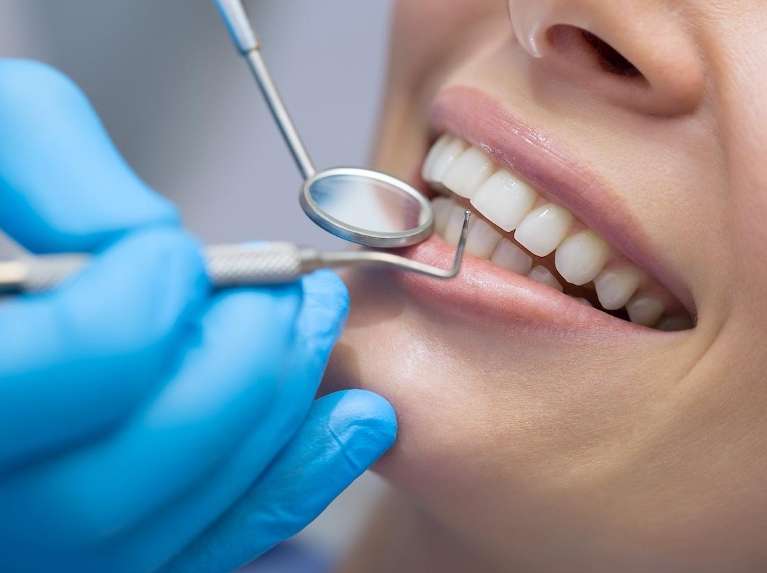 Woman smiling with dental tools near her mouth, scottsdale az