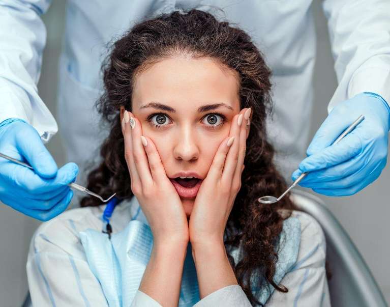 Woman with hands on face at dentist, scottsdale az