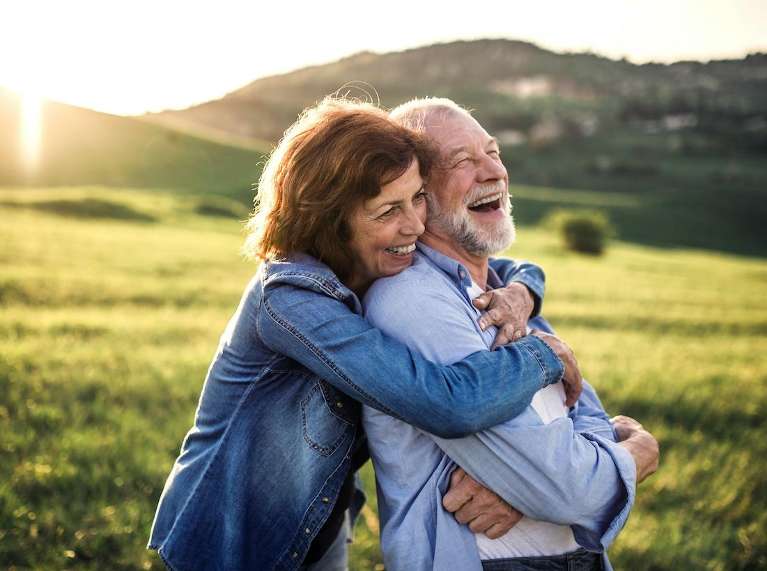 Woman hugging man smiling in field, scottsdale az