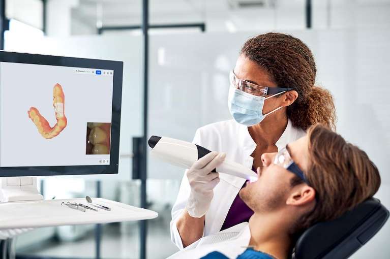 A woman using a PrimeScan 2 Digital Impressions at scottsdale cosmetic dentistry